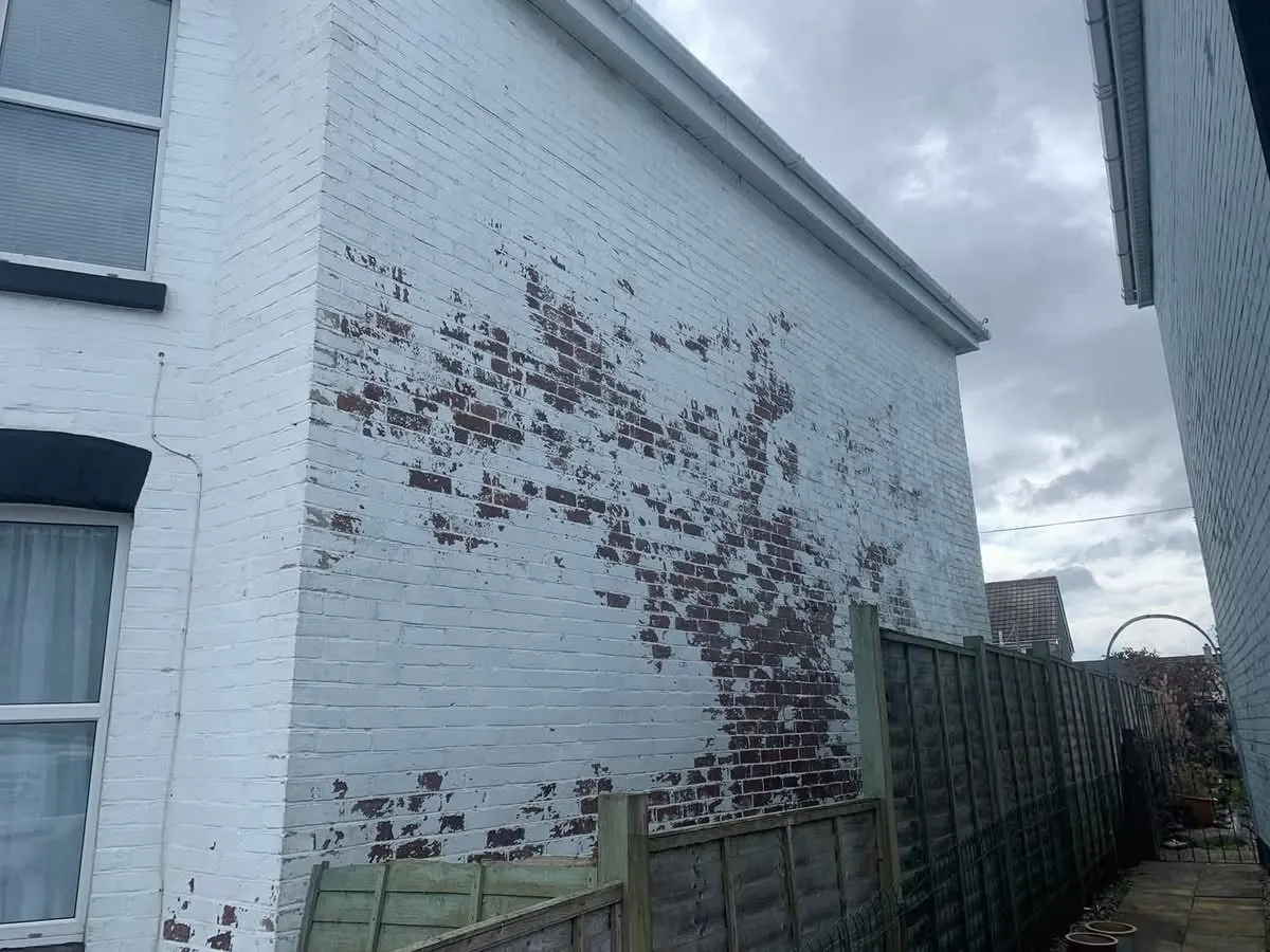 Peeling paint on a brick wall before redecoration in St Agnes